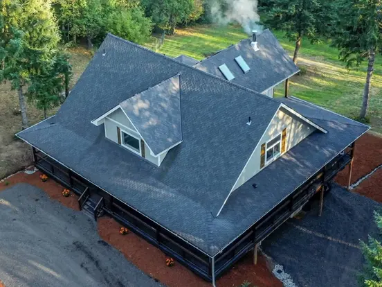 Aerial view of a home with a newly replaced dark gray shingle roof